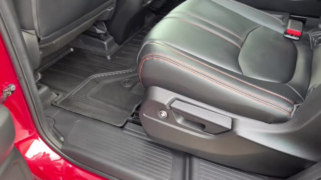 Black leather seat with red stitching and floor mats after detailing